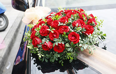 Rote Rosen schmücken den Hochzeitswagen