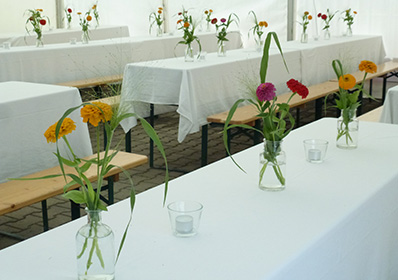 kleine Blumen-Arrangements in weißen Vasen zur Hochzeit